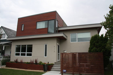 Small trendy beige split-level stucco exterior home photo in Calgary
