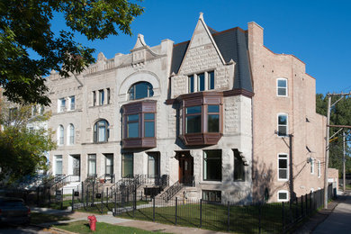 Example of a large gray three-story stone flat roof design in Chicago