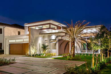 Example of a large trendy white two-story stucco exterior home design in Miami
