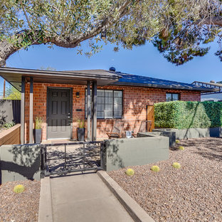 Transitional red one-story brick house exterior idea in Phoenix with a hip roof and a shingle roof