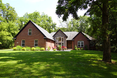 Imagen de fachada de casa roja clásica renovada de dos plantas con revestimiento de ladrillo, tejado a dos aguas y tejado de teja de madera