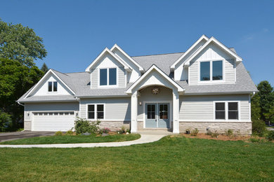Imagen de fachada de casa gris clásica de tamaño medio de dos plantas con revestimiento de madera, tejado a dos aguas y tejado de teja de madera
