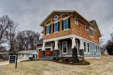 Diseño de fachada de casa multicolor de estilo americano grande de dos plantas con revestimiento de madera, tejado de teja de madera y tejado a dos aguas