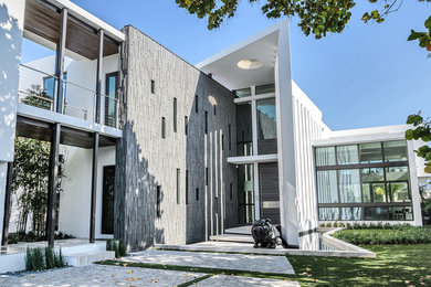 Diseño de fachada blanca minimalista extra grande de dos plantas con revestimiento de estuco y tejado plano