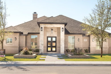 Example of a mid-sized trendy beige one-story brick exterior home design in Austin with a hip roof