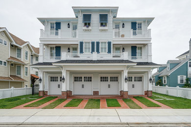 Example of a huge beach style blue three-story vinyl house exterior design in Philadelphia with a shingle roof