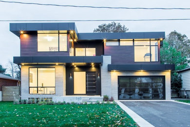 Foto de fachada de casa moderna grande de dos plantas con revestimiento de vidrio y tejado plano