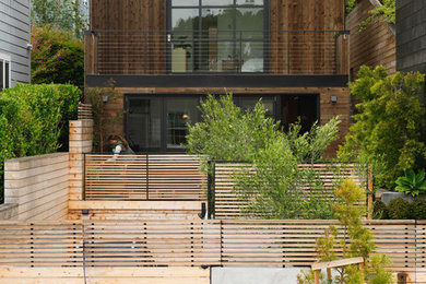 Foto de fachada de casa marrón moderna grande de tres plantas con revestimiento de madera, tejado a dos aguas y tejado de teja de madera