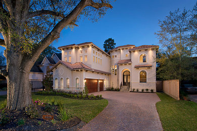 Mid-sized transitional beige two-story stucco house exterior idea in Houston with a hip roof and a tile roof