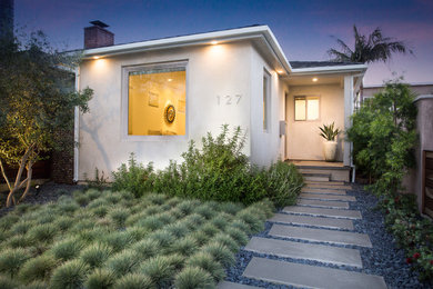 Ejemplo de fachada de casa gris minimalista de tamaño medio de una planta con revestimiento de estuco y tejado a cuatro aguas