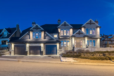 Huge elegant gray one-story stone exterior home photo in Calgary
