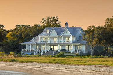 Example of a large blue three-story wood exterior home design in Charleston with a metal roof