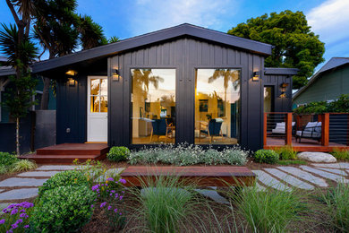Example of a huge trendy black one-story concrete fiberboard house exterior design in Los Angeles with a hip roof