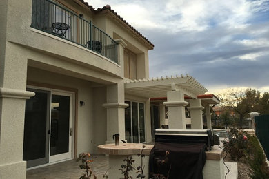 Large tuscan beige two-story stucco house exterior photo in Las Vegas with a hip roof and a tile roof