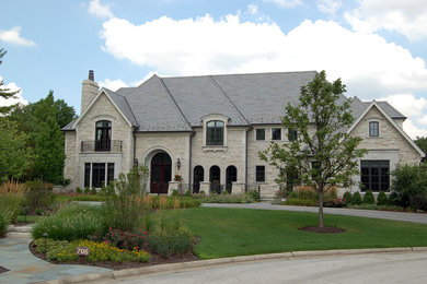 Large elegant two-story stone exterior home photo in Chicago with a hip roof