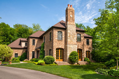 Example of a classic two-story brick exterior home design in Indianapolis with a hip roof