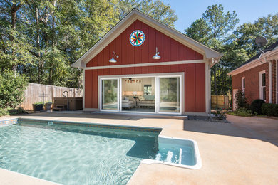 This is an example of a small and red beach style bungalow house exterior in Atlanta with concrete fibreboard cladding, a pitched roof and a shingle roof.
