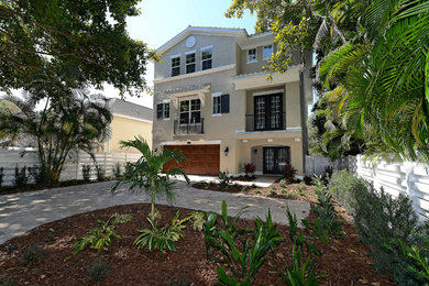 This is an example of a large and beige mediterranean render house exterior in Tampa with three floors and a pitched roof.