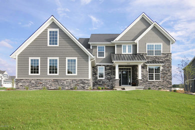 Example of a mid-sized transitional gray two-story mixed siding exterior home design in Grand Rapids with a shingle roof