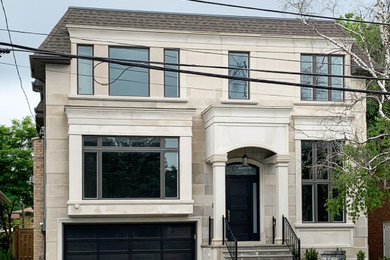 Mid-sized trendy beige two-story brick house exterior photo in Toronto with a gambrel roof and a mixed material roof