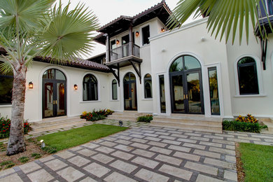 Imagen de fachada de casa blanca mediterránea grande de dos plantas con revestimiento de estuco