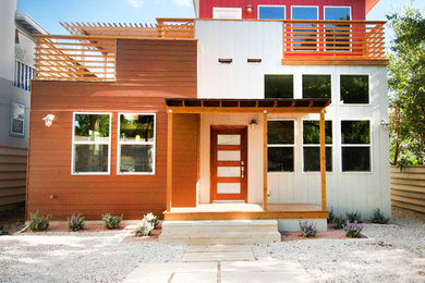 Mid-sized trendy red two-story wood exterior home photo in Austin