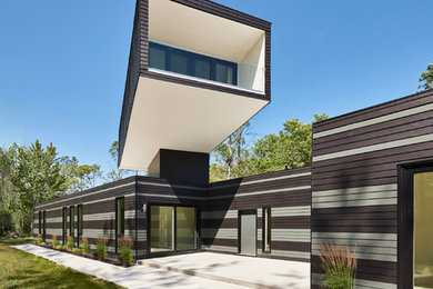 Esempio della facciata di una casa marrone contemporanea con rivestimento in legno e tetto piano