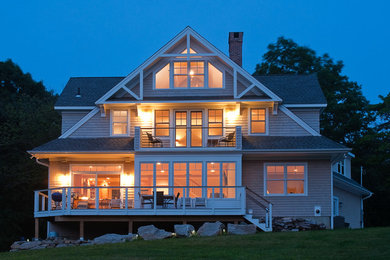 Идея дизайна: большой, трехэтажный, деревянный, серый частный загородный дом в морском стиле с двускатной крышей и крышей из гибкой черепицы