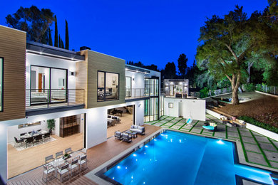 Example of a large minimalist white two-story stucco flat roof design in Los Angeles