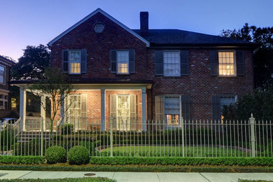 Inspiration for a large timeless red two-story brick exterior home remodel in New Orleans with a shingle roof