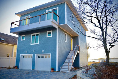 Immagine della villa blu stile marinaro con rivestimento con lastre in cemento e copertura in metallo o lamiera