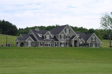 他の地域にある巨大なトラディショナルスタイルのおしゃれな家の外観 (石材サイディング) の写真