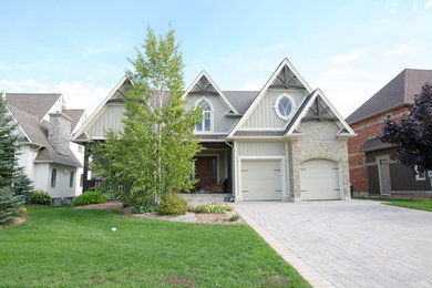 Example of a mid-sized transitional beige two-story mixed siding exterior home design in Toronto with a shingle roof