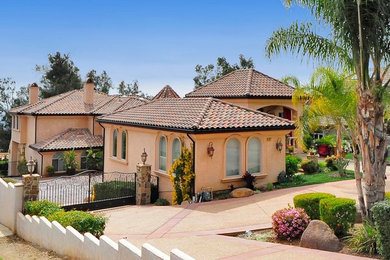 Großes Mediterranes Einfamilienhaus mit Putzfassade, Satteldach, beiger Fassadenfarbe und Ziegeldach in Los Angeles