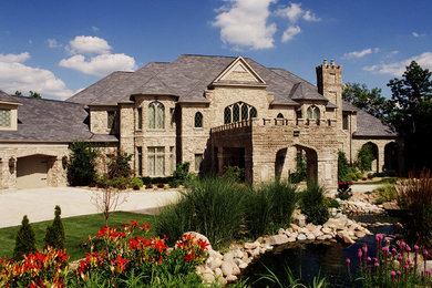 Inspiration pour une très grande façade de maison beige méditerranéenne en pierre à deux étages et plus.