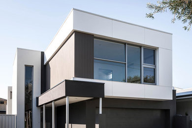 Modelo de fachada de casa blanca moderna de dos plantas con revestimientos combinados, tejado plano y tejado de metal