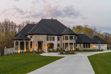 Mid-sized elegant beige two-story stone exterior home photo in Cincinnati with a tile roof