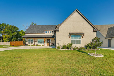 Inspiration for a transitional two-story brick house exterior remodel in Dallas with a shingle roof