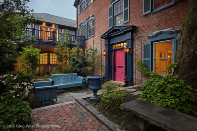 Example of a large eclectic red three-story brick exterior home design in Boston with a hip roof and a shingle roof