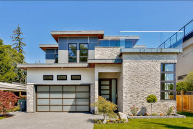 Ejemplo de fachada de casa beige minimalista de tamaño medio de dos plantas con revestimiento de piedra y tejado plano