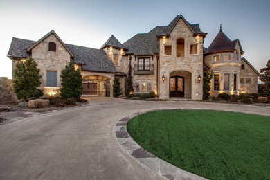 Example of a classic beige two-story stone exterior home design in Dallas
