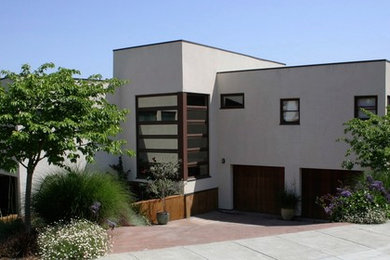 Идея дизайна: большой, трехэтажный, бежевый дом в стиле модернизм с облицовкой из цементной штукатурки