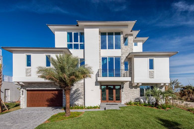 Inspiration for a large coastal three-story stucco house exterior remodel in Orlando