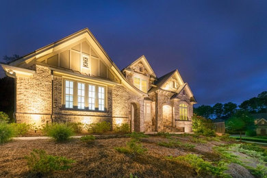 Huge traditional brown three-story stone exterior home idea in Atlanta with a mixed material roof