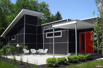 Idée de décoration pour une façade de maison noire urbaine de taille moyenne et de plain-pied avec un toit plat.
