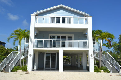 Large island style blue three-story vinyl exterior home photo in Miami