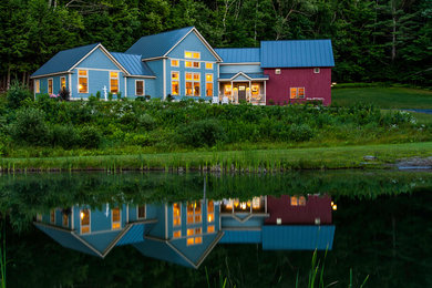 Diseño de fachada de casa azul clásica grande de dos plantas con revestimiento de madera y tejado a dos aguas