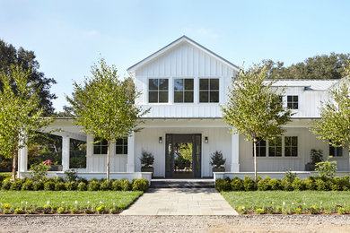 Ejemplo de fachada blanca actual grande de dos plantas con tejado a dos aguas y revestimiento de madera