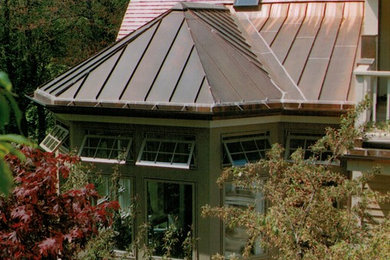 Modelo de fachada marrón clásica renovada de tamaño medio de una planta con revestimiento de estuco y tejado a la holandesa