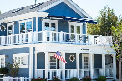 Inspiration for a large timeless blue two-story wood gable roof remodel in New York